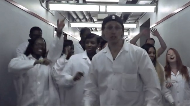 A man in a lab coat rapping.