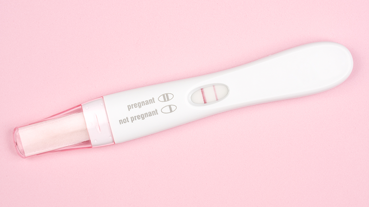 Image of a pregnancy test with pink background