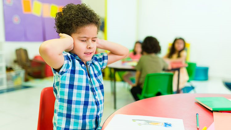 Child with hands over his ears