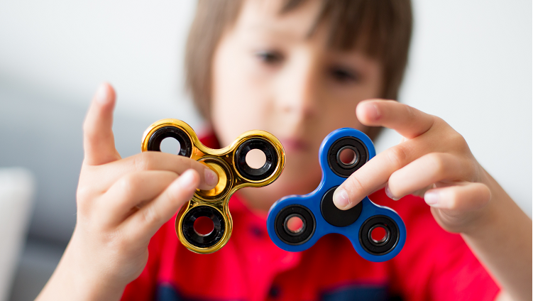 Boy playing with fidget spinners