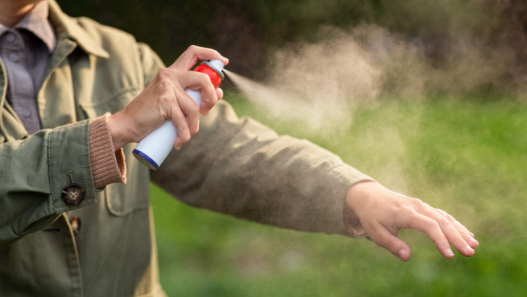 Person spraying bus spray on clothes