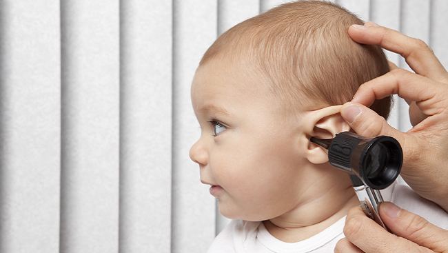 Baby with someone listening to its ear