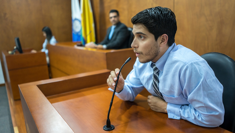 Man speaking on stand in a courtroom