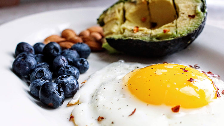 blueberries nuts eggs and avocado on a plate
