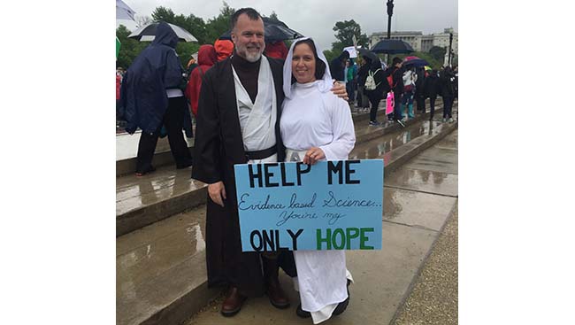 Marchers dressed as Star Wars characters Luke Skywalker and Princess Leia with a sign that reads: "Help me evidence based Science you're my only hope."