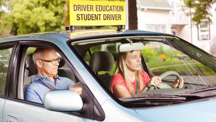 Photogprah of a scared teen driving with an adult is in the passenger's seat