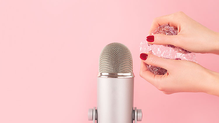 Hands holding bubble wrap near microphone
