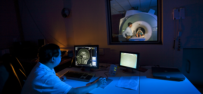 Man monitoring a child in an MRI  scanner.