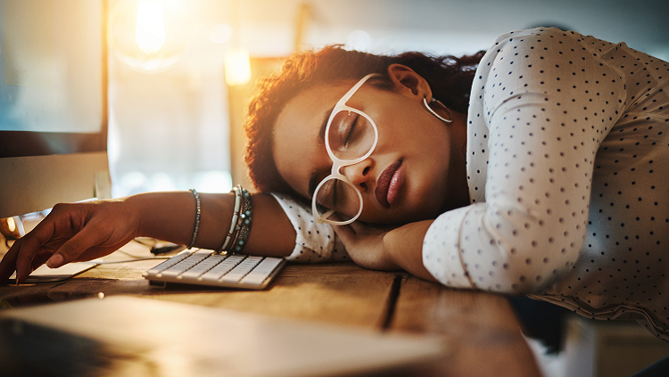 Image of a woman who has fallen asleep at her desk